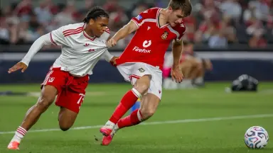 Rio Ngumoha Chelsea add-on: Rio Ngumoha in a Liverpool match action photo, wearing a white Liverpool kit and contesting the ball against Wrexham.